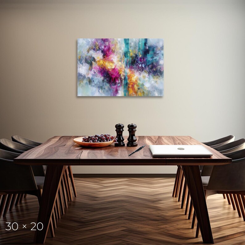 May include: Abstract canvas art with vibrant colors of pink, yellow, teal, and purple. The artwork is 30 x 20 inches and hangs above a wooden dining table. The table is set with a bowl of grapes, salt and pepper shakers, a pen, and a laptop.