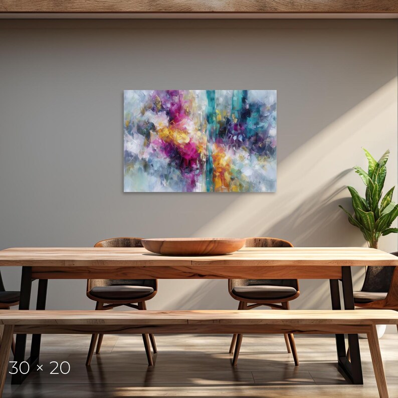 May include: Abstract art canvas print with dimensions of 30 x 20 inches. The artwork features a vibrant mix of colors, including pink, yellow, teal, and blue, creating a dynamic and expressive composition. The painting is displayed above a wooden dining table.