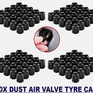 Puede incluir: Se muestran varios juegos de tapones negros para válvulas de aire de neumáticos. Un primer plano muestra una mano instalando un tapón. El texto en la parte inferior dice "100X DUST AIR VALVE TYRE CAPS".