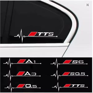 May include: White car window decal with a heartbeat graphic and the letters "TTS" in white and red. Additional decals with "A1", "A3", "Q5", "S6", "SQ5", and "TTS" are also shown.