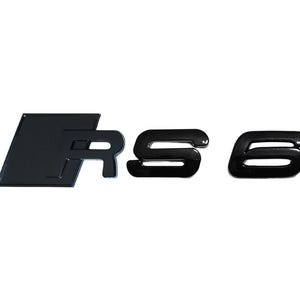 以下が含まれることがあります： 文字「RS」と数字「6」をあしらった光沢のある黒い自動車用エンブレム。Rは斜めの平行四辺形の形状に統合されており、その後にSと6が続き、全体が大胆でモダン、かつ反射性のある仕上げになっています。