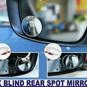 May include: A close-up of a car side mirror with two small, round blind spot mirrors attached. The blind spot mirrors are white with a red accent. The text "2X BLIND REAR SPOT MIRROR" is displayed at the bottom of the image.
