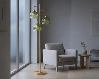 Złota lampa podłogowa z zielonym szklanym kloszem, nowoczesna lampa stojąca, oświetlenie w stylu mid-century, wystrój salonu, eleganckie oświetlenie domu