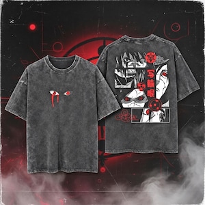 May include: A charcoal grey acid-wash t-shirt featuring a small graphic of two eyes with red irises and a red tear on the front. The back displays a large black and white manga-style collage with red accents, Japanese text, and red cloud symbols.