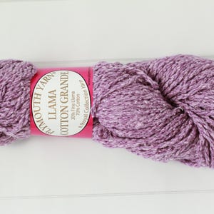May include: A skein of Plymouth Yarn Llama Cotton Grande in a lavender color. The yarn is a blend of 30% fine llama and 70% cotton. The label is pink with white text. The yarn is a Royal Collection Yarn.