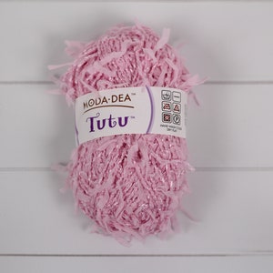 May include: A pink ball of yarn with a label that reads "Moda-Dea Tutu" and includes care instructions.