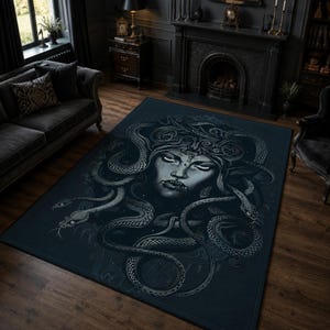 Può includere: Un tappeto rettangolare con un'illustrazione grafica blu scuro e grigia di una figura di Medusa con serpenti al posto dei capelli. Il design mostra un volto centrale con occhi intensi circondato da serpenti avvolti su uno sfondo blu navy.