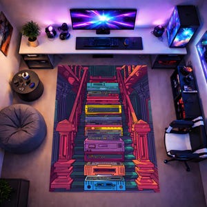 Puede incluir: Una colorida alfombra con un diseño de escalera, que presenta una pila de dispositivos electrónicos antiguos. La alfombra está en un entorno de sala de juegos, con un escritorio, una computadora y una silla. La paleta de colores incluye rojo, morado, amarillo y azul.