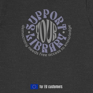 May include: A dark gray t-shirt featuring a circular graphic with the text SUPPORT YOUR LIBRARY in light purple and gray, and the smaller text democracy needs free access to knowledge in a circle below it. The shirt includes a small EU flag icon.