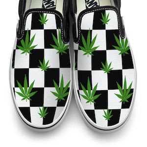 May include: Black and white chequered slip-on shoes with green marijuana leaf designs.