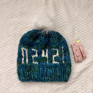 Può includere: Una tazza di ceramica bianca con manico nero e la scritta "But First, Coffee" in nero, con un carattere a mano. La tazza è su una superficie bianca.