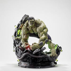 Puede incluir: Estatua detallada de Hulk en una pose dinámica, con un físico verde musculoso y pantalones negros. La figura está sobre una base negra con detalles verdes y grises, y un diseño futurista.