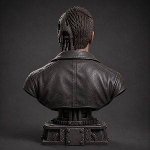 May include: A bust of a figure wearing a dark leather jacket, featuring short brown hair and a mechanical skull structure exposed on the right side. The base is a dark gray industrial platform with visible gears and metallic bolts.