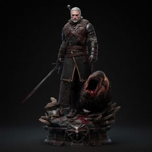 May include: A detailed statue of a character from The Witcher series, standing over a monster's severed head. The figure is clad in dark armor and holds a sword. The base features the Witcher medallion and a detailed, dark aesthetic.