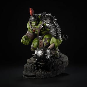 Könnte beinhalten: Eine grüne Hulk-Statue in Gladiatorrüstung, die eine stachelige Keule hält. Die Figur hat einen Helm mit roter Feder und steht auf einem felsigen Sockel. Die Rüstung ist metallisch, und die Statue hat einen detaillierten, muskulösen Körperbau.