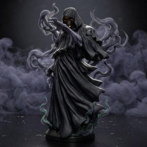 Pode incluir: Uma figura escura encapuzada de um esqueleto com um crânio de cor dourada. A figura veste uma túnica preta longa e fluida e está rodeada por volutas de fumo cinzento translúcido que se elevam a partir da base da estatueta.