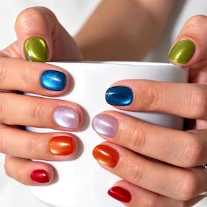 May include: Fingernails painted in a vibrant gradient of colors including lime green, deep blue, soft lavender, bright orange, and cherry red. Each nail features a smooth, glossy, and reflective finish, creating a polished and colorful appearance.
