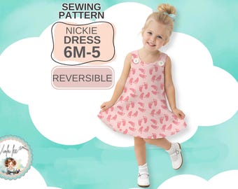 May include: A sewing pattern for a reversible Nickie dress in sizes 6M-5, featuring a light pink sleeveless dress with a repeating pattern of darker pink baby footprints and two white buttons at the shoulders, displayed on a light blue background.