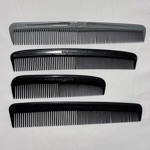 May include: Four combs of varying sizes are displayed against a white background. The top comb is gray, while the other three are black. The black combs have the word "Unbreakable" printed on them.
