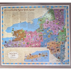 Puede incluir: Un rompecabezas completo de Nueva York, con un mapa detallado con ilustraciones de lugares emblemáticos y puntos de interés. El rompecabezas incluye el texto "Remarkable New York State" y "New York State". El rompecabezas está enmarcado con un borde azul.
