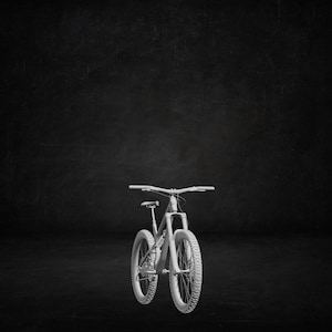 May include: A white mountain bike with chunky tyres and a suspension system. The bike has a curved handlebar and a seat. The image is set against a dark background.