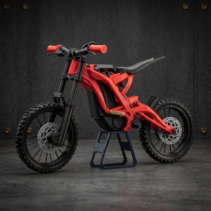 Könnte beinhalten: Ein rotes Elektro-Dirtbike-Modell mit schwarzem Lenker, schwarzen Rädern mit Bremsscheiben und einem schwarzen Sitz. Das Motorrad steht auf einem kleinen blauen Ständer und zeigt ein detailliertes Rahmendesign mit orangefarbenen Griffen und kompakter Bauweise.