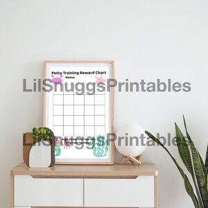 May include: A framed potty training reward chart with a light wood frame. The chart features a grid for stickers, with illustrations of sea creatures. Text at the top reads "Potty Training Reward Chart". The bottom text says "Add a sticker each time your child uses the potty".