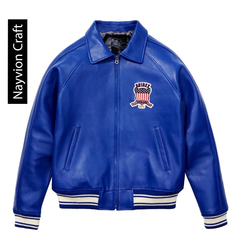 May include: A vibrant blue leather jacket with a classic bomber style. Features a zip-up front, a collared neckline, and a patch on the chest with a red, white, and blue design. The cuffs and hem have white stripes. The text "Navyion Craft" is on the left side.