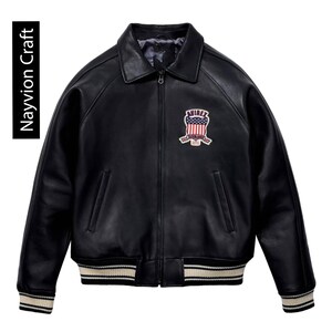 May include: Black leather jacket with a collared neckline, a zipper closure, and a patch on the chest. The jacket has ribbed cuffs and a ribbed hem with cream and black stripes. The text "Navyion Craft" is on the left side.