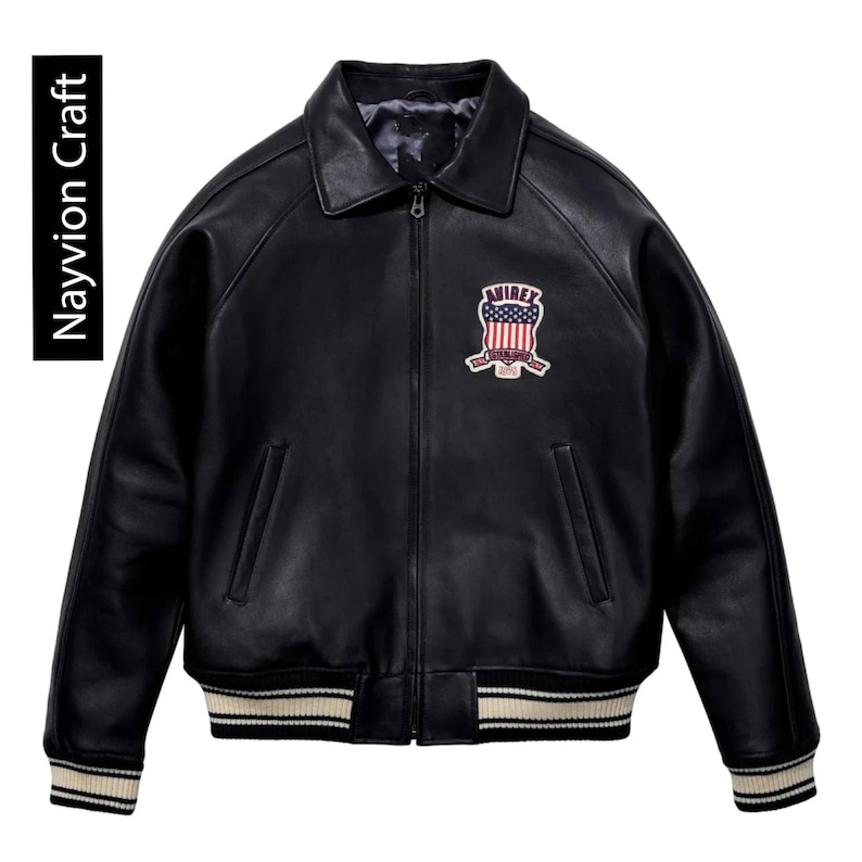 May include: Black leather jacket with a collared neckline, a zipper closure, and a patch on the chest. The jacket has ribbed cuffs and a ribbed hem with cream and black stripes. The text "Navyion Craft" is on the left side.
