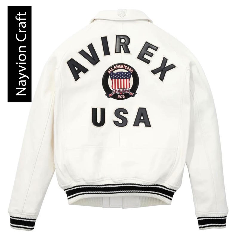 May include: Cream-colored bomber jacket with black and white striped cuffs and hem. The back features the word "AVIREX" above a circular emblem with "ALL AMERICANS ESTABLISHED 1975" and a USA flag design. Below is the word "USA".
