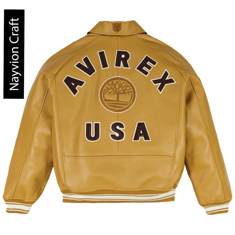 May include: A tan leather jacket with the word "AVIREX" arched across the back in brown letters, with "USA" below. The jacket has a ribbed collar and cuffs with white stripes. The brand name "Navyion Craft" is printed vertically on the left side.
