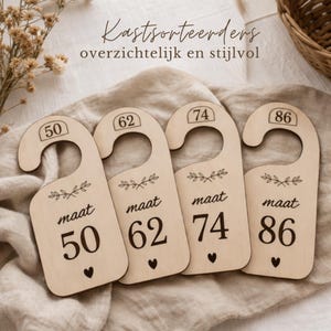 Op de afbeelding: Vier houten kastverdelers met de nummers 50, 62, 74 en 86. Elke verdeler heeft een gebogen bovenkant om op te hangen, het woord "maat" en een klein hartje. De tekst "Kastsorteerders overzichtelijk en stijlvol" staat bovenaan.