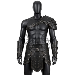 Pode incluir: Um conjunto de armadura de gladiador em couro preto exibido em um manequim. O conjunto inclui uma ombreira, protetores de braço, um cinto com saia e tiras. A armadura é detalhada com rebites e fivelas, sugerindo um tema histórico ou de fantasia.