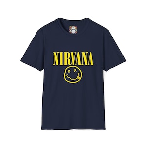 Peut inclure: T-shirt bleu marine avec le mot "NIRVANA" en jaune au-dessus d'un smiley jaune avec des yeux barrés et une langue tirée. Le t-shirt est de style col rond.