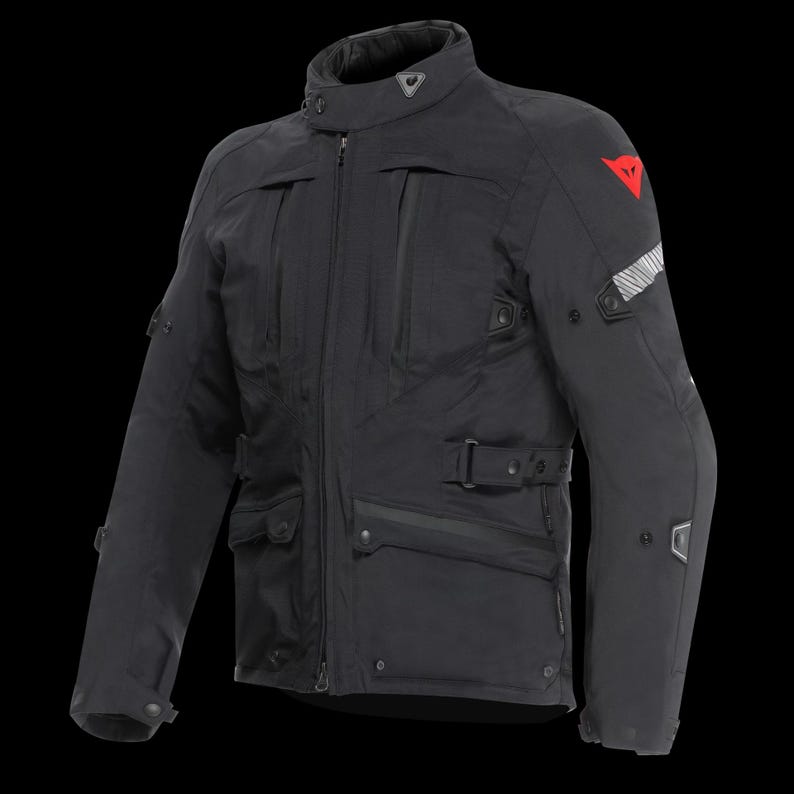 May include: Black motorcycle jacket with multiple pockets, a high collar, and a zip-up front. Features a red logo on the upper arm and reflective stripes. The jacket has a belt at the waist and reinforced elbow pads.