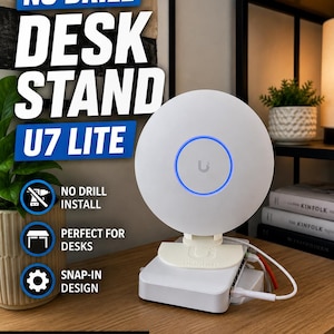 May include: A white U7 Lite desk stand with a blue illuminated ring. The stand is designed for Ubiquiti U7 Lite and features a snap-in design. Text on the image reads "NO DRILL DESK STAND U7 LITE".