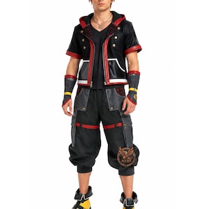 May include: A black and red cosplay costume featuring a short-sleeved jacket with gold buttons, a black V-neck shirt, and black cargo pants. The costume includes wrist cuffs and black boots with yellow accents. The jacket has a red plaid pattern on the hood.