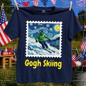 Könnte beinhalten: Ein marineblaues Kurzarm-T-Shirt mit einem quadratischen Aufdruck, der wie eine Briefmarke gestaltet ist. Das Bild zeigt einen Skifahrer in grüner Jacke auf einer verschneiten Piste vor einem wirbelnden Sternenhimmel. Der Text "Gogh Skiing" ist gelb.