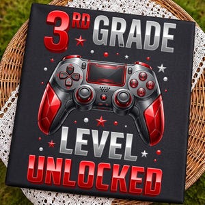 Könnte beinhalten: Ein schwarzes rechteckiges Schild mit einer roten und silbernen Videospiel-Controller-Grafik in der Mitte. Der Text lautet 3RD GRADE oben und LEVEL UNLOCKED unten in fetter roter und silberner Schrift, akzentuiert durch kleine rote Sterne und Punkte.