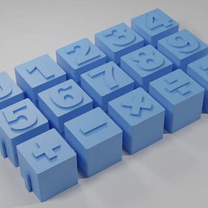 May include: Sixteen light blue cube blocks, each with a different number or mathematical symbol embossed on top. The blocks are arranged in a grid. The numbers and symbols are in a raised design on the blocks.