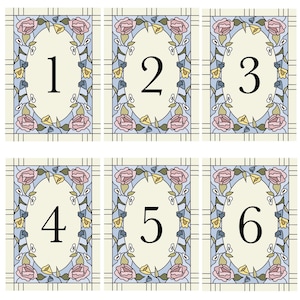 Op de afbeelding: Zes decoratieve kaarten met de nummers 1 tot en met 6. Elke kaart heeft een crèmekleurige achtergrond met een centraal ovaal met een groot zwart nummer. Het ovaal is omlijst door een bloemenrand met roze rozen, gele en blauwe bloemen en groene bladeren.