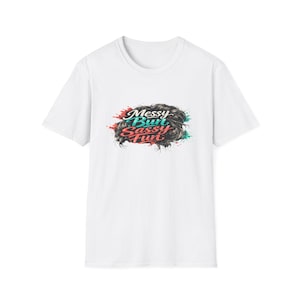 May include: White t-shirt with a graphic that says "Messy Bun Sassy Fun." The graphic features a messy bun design with red, teal, and black accents. The shirt is a classic crew neck style.