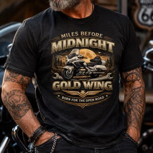 Puede incluir: Camiseta gris oscuro con un diseño de motocicleta. El diseño incluye las palabras "Miles Before Midnight" y "Gold Wing", una motocicleta, una luna llena y la frase "Born for the Open Road."