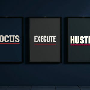 May include: Three framed motivational posters. The first poster is navy blue with the word "FOCUS" in white, underlined with a red line. The second poster is black with "EXECUTE" in white, underlined with red. The third poster is black with "HUSTLE" in white, underlined with red.