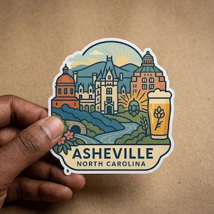 Op de afbeelding: Een gestanste sticker met een kleurrijke illustratie van de skyline van Asheville, North Carolina, inclusief het Biltmore Estate, bergen, een zonsopgang en een glas bier met een hop-icoon, met de tekst ASHEVILLE NORTH CAROLINA eronder.