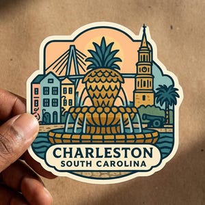 Peut inclure: Un autocollant découpé présentant une illustration stylisée de la fontaine ananas de Charleston, du pont Ravenel et d'un clocher d'église. Le design comprend un canon, un palmier et le texte Charleston South Carolina en bleu foncé.