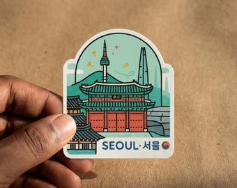 May include: A die-cut sticker featuring a stylized illustration of a traditional Korean palace building in red and green, with the N Seoul Tower and Lotte World Tower in the background. The text SEOUL and Korean characters are printed at the bottom.