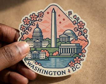 May include: A die-cut sticker featuring a stylized illustration of Washington D.C. landmarks including the Capitol, Washington Monument, and White House, framed by pink cherry blossoms against a peach sky, with the text WASHINGTON DC at the base.