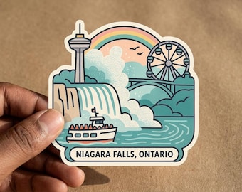 May include: A die-cut sticker featuring a stylized illustration of Niagara Falls, Ontario. The design includes a tall observation tower, a ferris wheel, a bridge, a boat on the water, and a rainbow. The text Niagara Falls, Ontario is printed at the bottom.